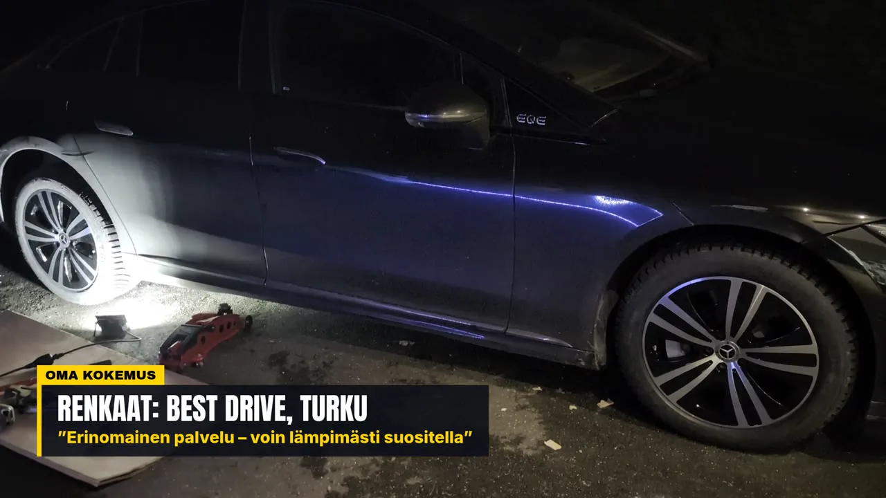 Mercedes-Benz EQE at night with Michelin studded winter tyres on both visible wheels, jack and tools still on the ground