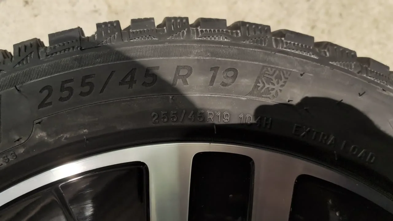 Close-up of a Michelin tyre sidewall moulded 255/45 R 19, with 255/45R19 104H, EXTRA LOAD, and a three-peak mountain snowflake